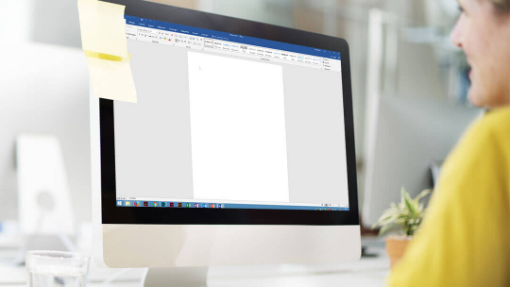 Person, die vor einem Bildschirm mit Word sitzt.